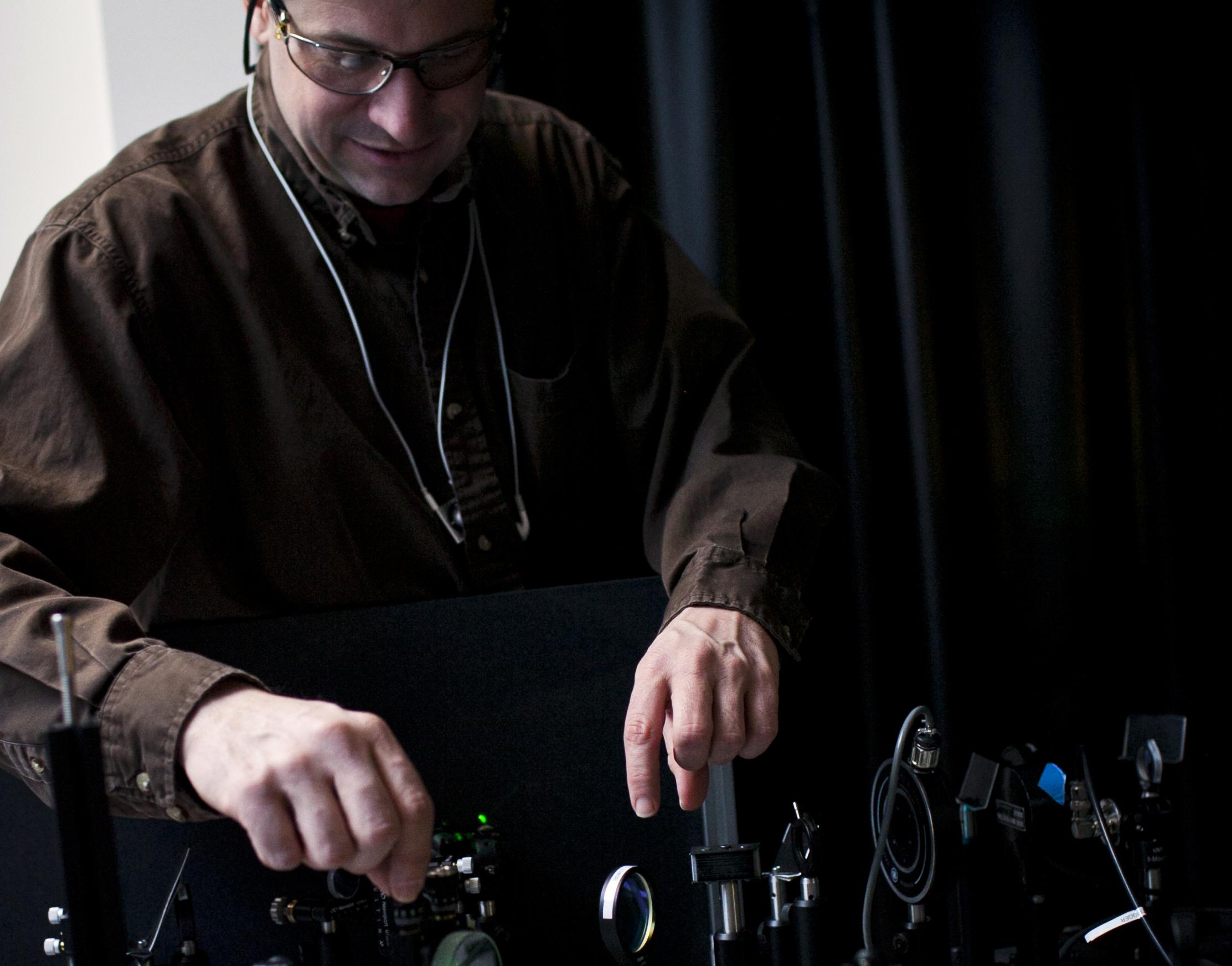 ISN Principal Research Scientist at a laser table in the ISN facility