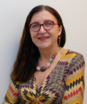 A woman stands in front of a wall